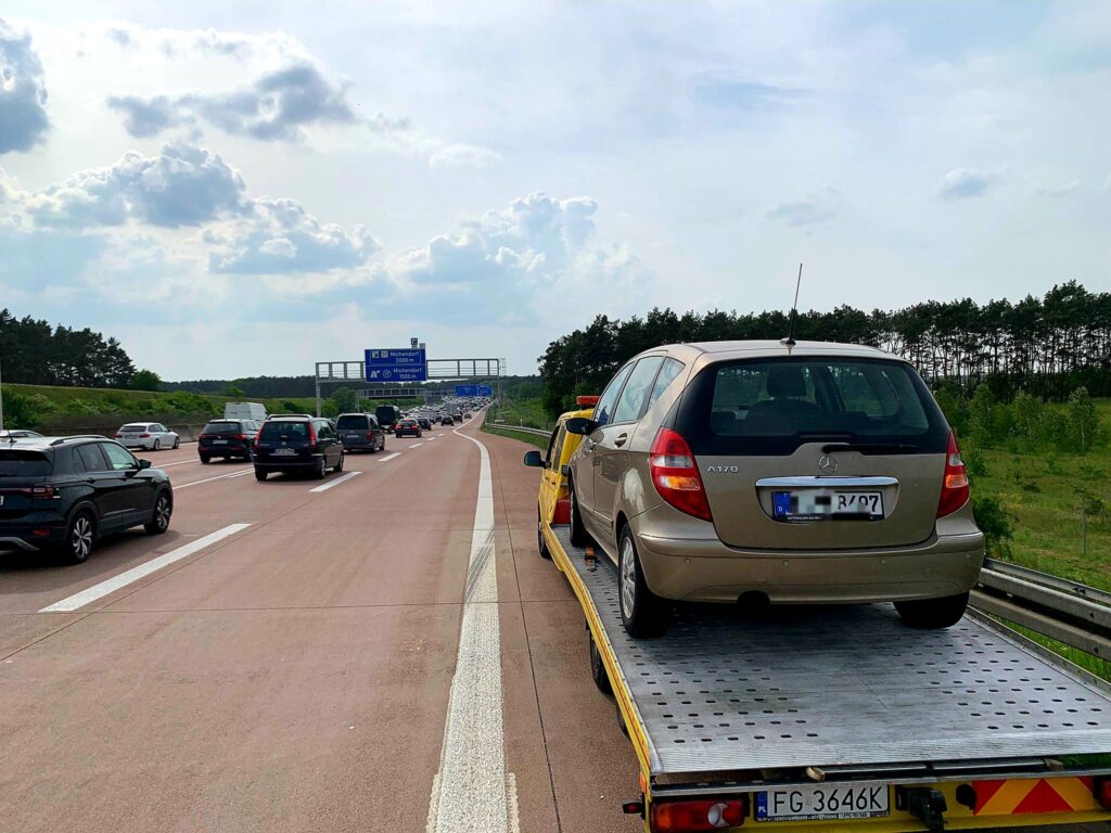 Zdjęcie przedstawia lawetę holującą samochód w Berlinie. Dowiedz się, jak uniknąć problemów na drodze dzięki profesjonalnym usługom holowniczym w Berlinie.