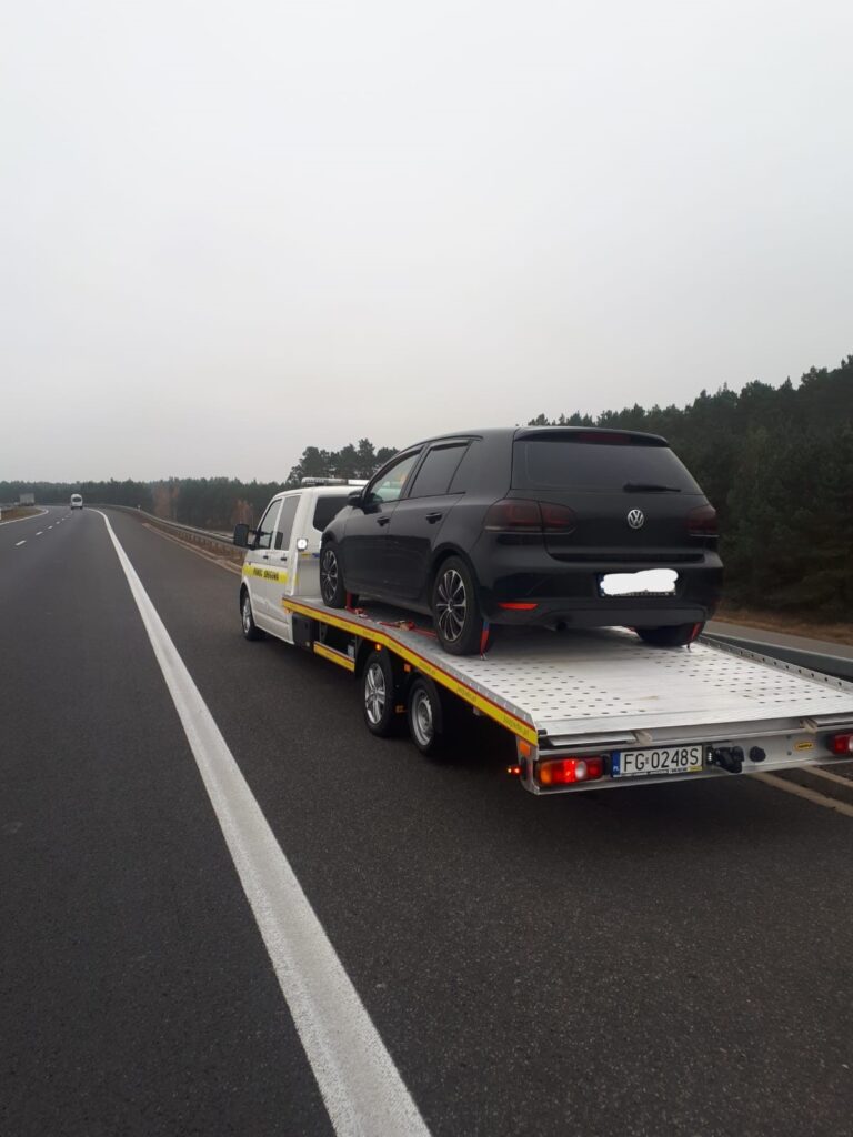 Laweta w Berlinie przewożąca samochód osobowy po miejskiej drodze – niezawodny transport pojazdów w sytuacjach awaryjnych.